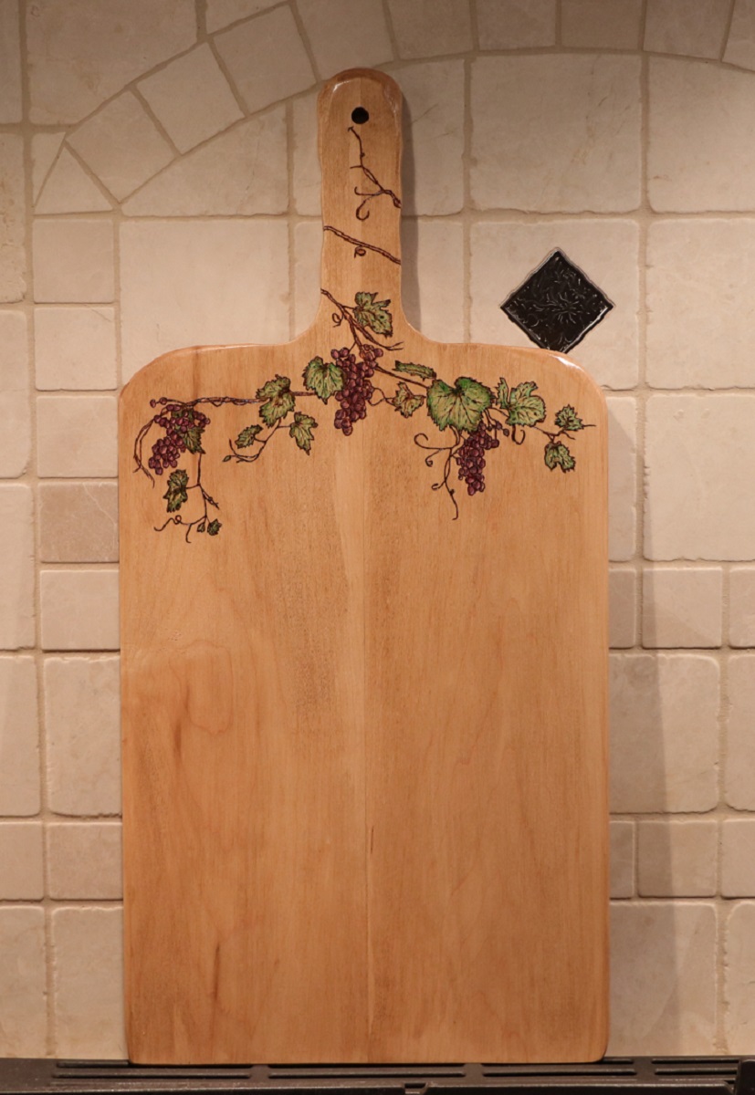 Grapebine and leaves woodburned into a maple charcuterie board