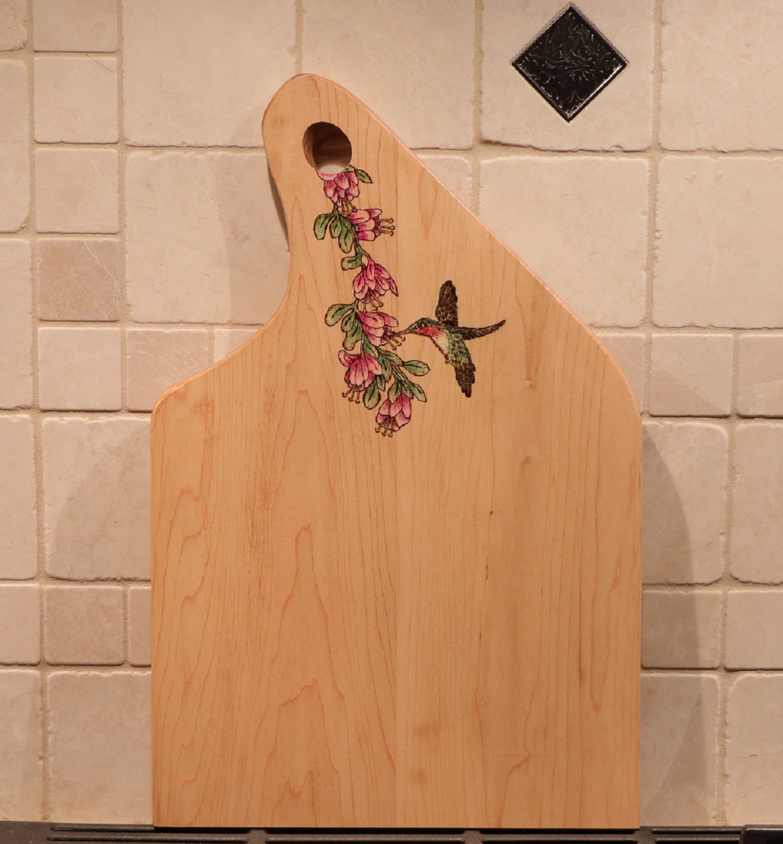 maple charcuterie board with woodburned hummingbird and flower  plus pencill coloring