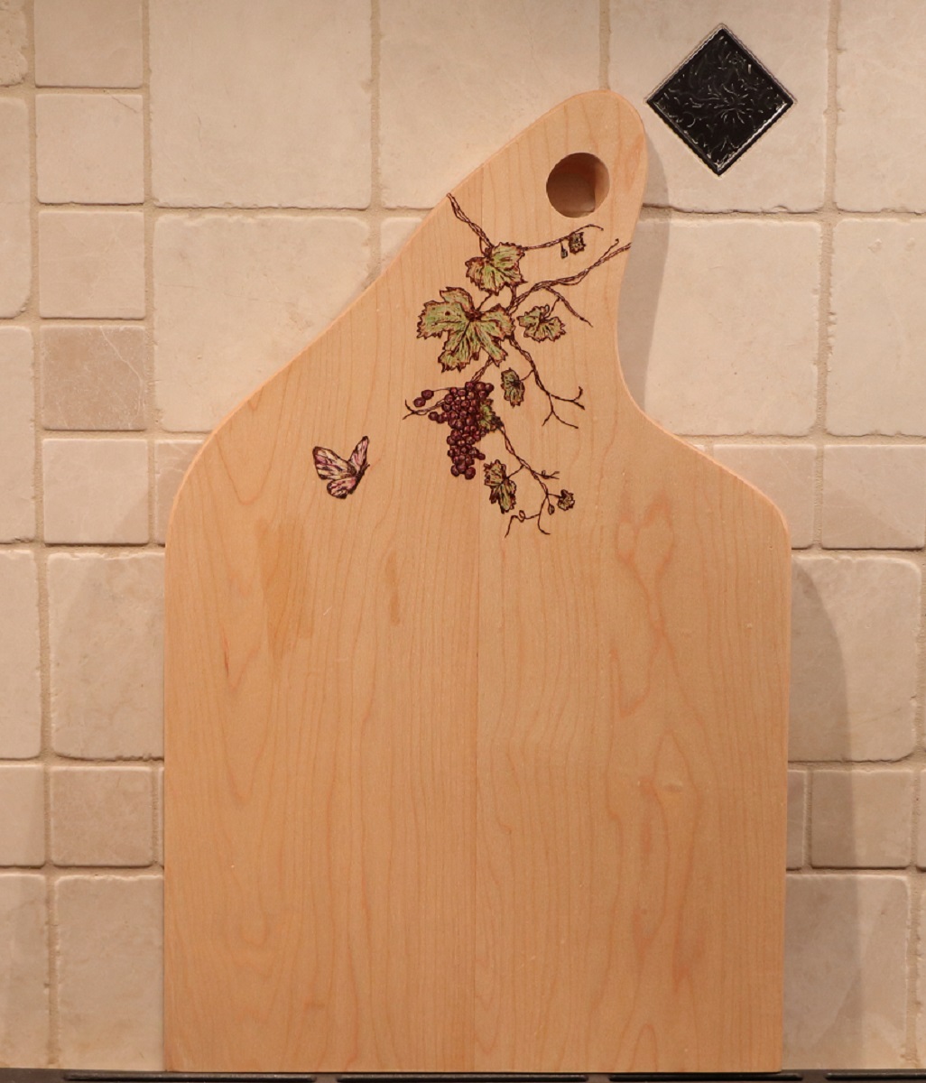 maple charcuterie board with woodburned grapevine and butterfly plus pencil coloring