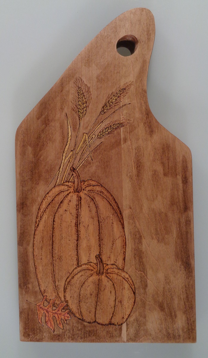 charcuterie board with woodburned pumpkin and wheat