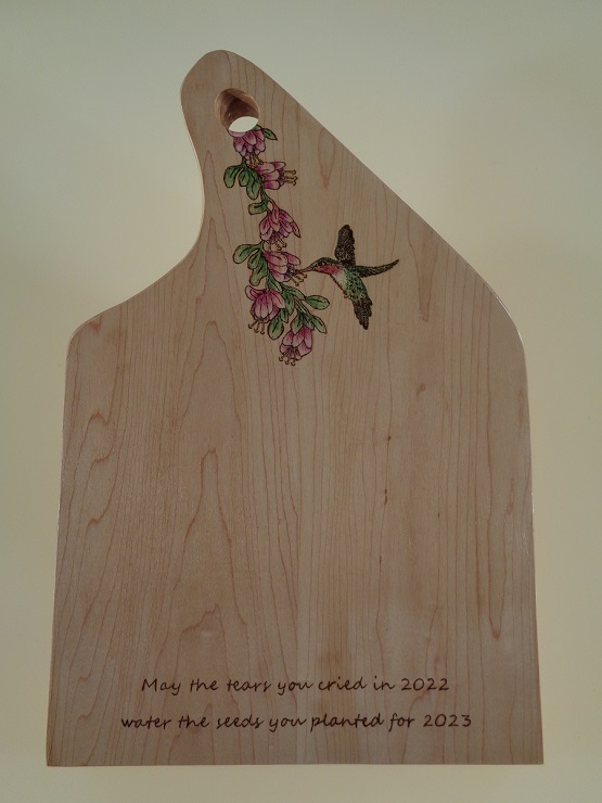 charcuterie board with woodburned hummingbird  and flower