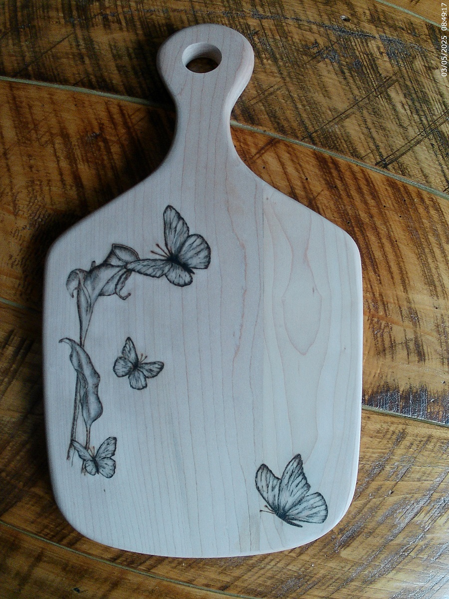 maple charcuterie board with woodburned buttflies and calla llily